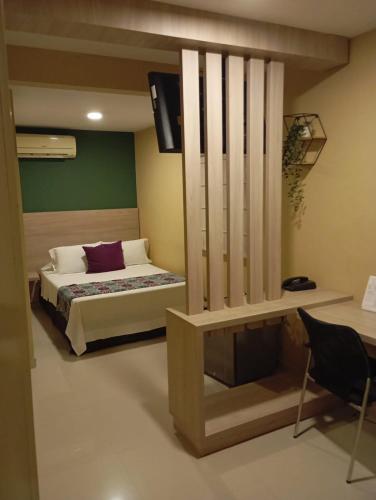 a bedroom with a bed and a desk at Hotel Prado 34 West in Bucaramanga
