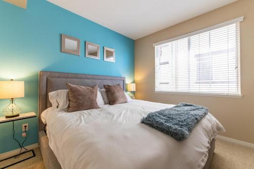 a bedroom with a bed with blue walls and a window at Luxury Suite, Fast Wifi, King Bed, Pool And Spa in Santa Clarita
