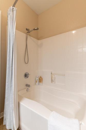 a white bath tub in a bathroom with a shower at Luxury Suite, Fast Wifi, King Bed, Pool And Spa in Santa Clarita