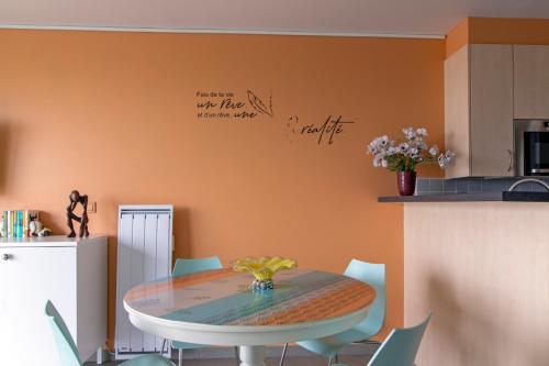 a dining room with a table and chairs at L'arc en ciel in Bray-Dunes