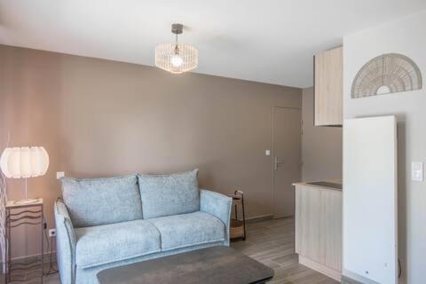 un salon avec un canapé bleu et une table dans l'établissement Aux cerisiers Olivet, à Olivet