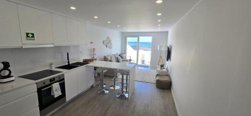 a kitchen with white cabinets and a counter top at Inside The Sea in Lagoa