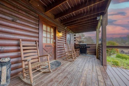 ピジョン・フォージにあるER24 - Honeysuckle Holler - Great Location,,Close to town cabinのロッキングチェアが2脚置かれた丸太小屋のポーチ