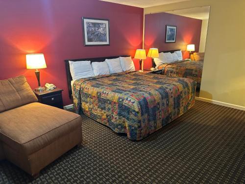 a hotel room with two beds and a couch at Royal Inn - Anniston in Anniston