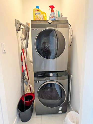 a microwave and a washing machine in a room at Central 5 Bedroom, AC, Rogers, Commonwealth, EXPO in Edmonton