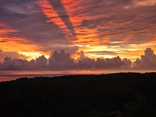 a sunset over the ocean with clouds in the sky at Casona Cocobolo el mejor lugar de Costa Rica in Guanacaste