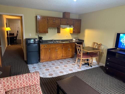 a kitchen with wooden cabinets and a table in a room at Royal Inn - Anniston in Anniston