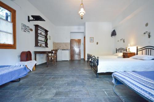 a room with two beds and a piano in it at Naxos Filoxenia Hotel in Galini