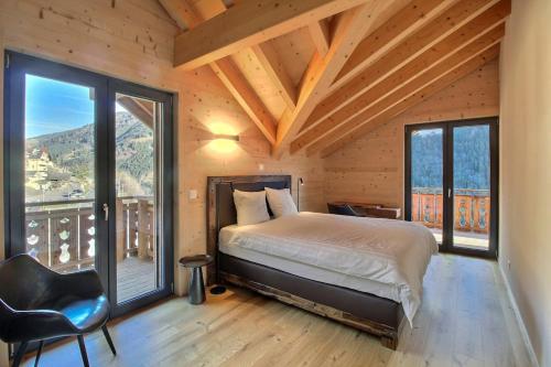 Un dormitorio con una cama y una ventana grande. en Source 24 Penthouse Spectacular View, en Champéry