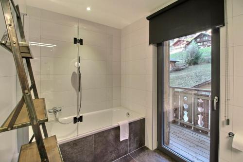 baño con bañera y ventana en Source 24 Penthouse Spectacular View, en Champéry