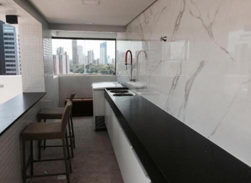 a kitchen with a counter and a sink and a window at Flat 1305 Manaíra Apart Hotel - JP in João Pessoa