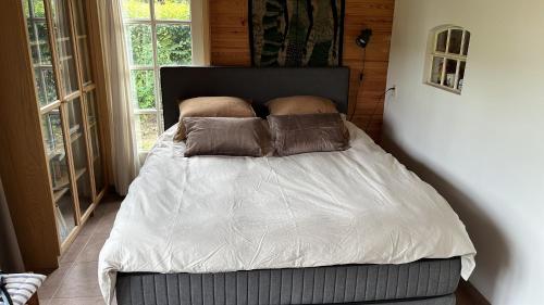 a bed with two pillows on it in a bedroom at Doevelsteeg Ommen in Arriën