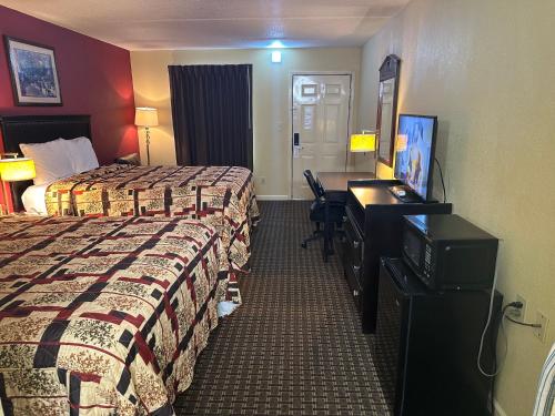 a hotel room with two beds and a desk at Royal Inn - Anniston in Anniston