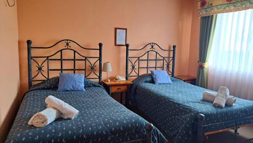 two beds in a bedroom with towels on them at Hotel Doria in Rancagua