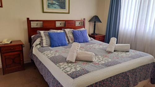 a bedroom with a large bed with blue pillows at Hotel Doria in Rancagua