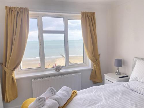 1 dormitorio con ventana y vistas a la playa en Duver at the Aqua, en Shanklin
