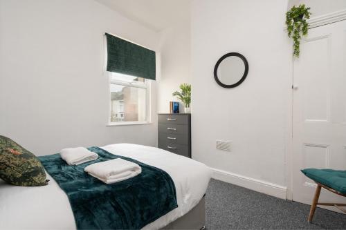 a white bedroom with a bed and a chair at Entire 5 Bedroom home in Birkenhead-Free Parking, Group & Family-Friendly, Free Internet in Birkenhead