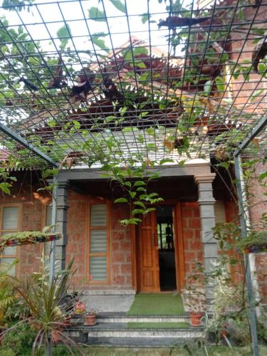 a brick house with a window and some plants at Kanav homestay in Kannur