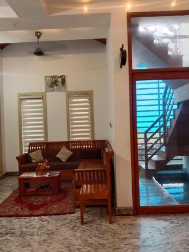 a living room with a couch and a staircase at Kanav homestay in Kannur