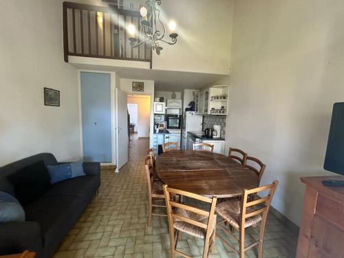 - une salle à manger et un salon avec une table et des chaises en bois dans l'établissement Appartement Village Camargue, au Grau-du-Roi