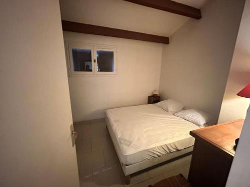 - un petit lit dans une petite chambre avec fenêtre dans l'établissement Appartement Village Camargue, au Grau-du-Roi