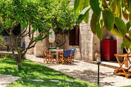 a patio with a table and chairs under a tree at Villa Aloni in Fílippos