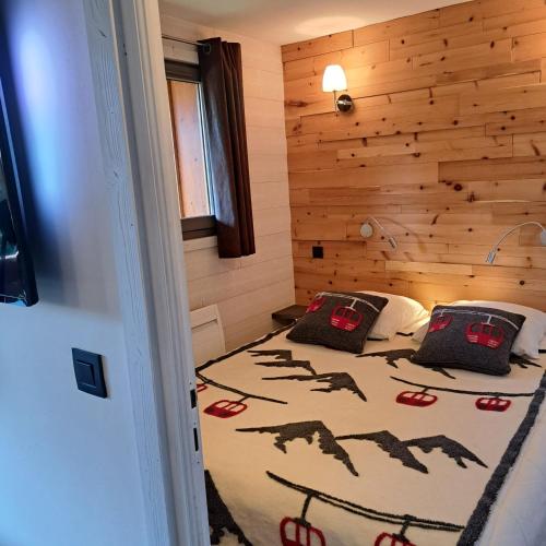 une chambre avec un lit dans une pièce en bois dans l'établissement Les Fermes Mégevannes, à Megève