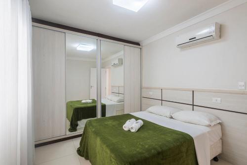 ein Schlafzimmer mit einem Bett mit zwei Handtüchern darauf in der Unterkunft GRJA012- Apê na Atlântica com terraço privilegiado in Balneário Camboriú
