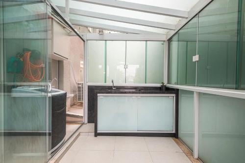 ein Raum mit grünen Glaswänden und einem Waschbecken in der Unterkunft GRJA012- Apê na Atlântica com terraço privilegiado in Balneário Camboriú