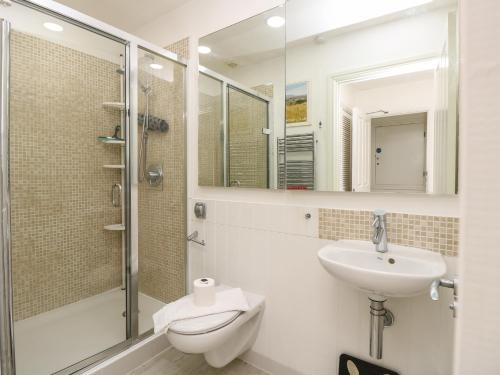 a bathroom with a toilet and a sink and a shower at Whitfield P7 in Yarmouth