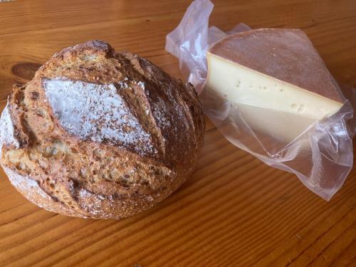 une miche de pain avec un bloc de fromage sur une table dans l'établissement Studio La Dranse, centre-ville, parking, navette et vue montagne, à Châtel