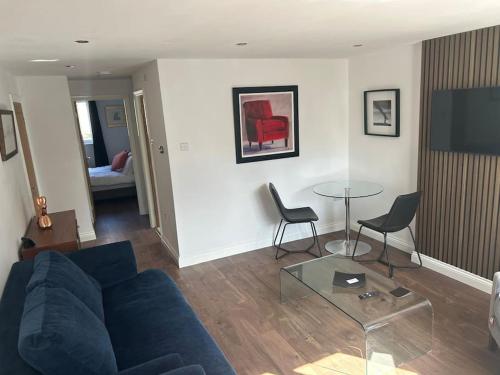 a living room with a blue couch and a glass table at Best rated in Barnsley- apartment sleeps 4 & 5 minute walk to town centre in Barnsley