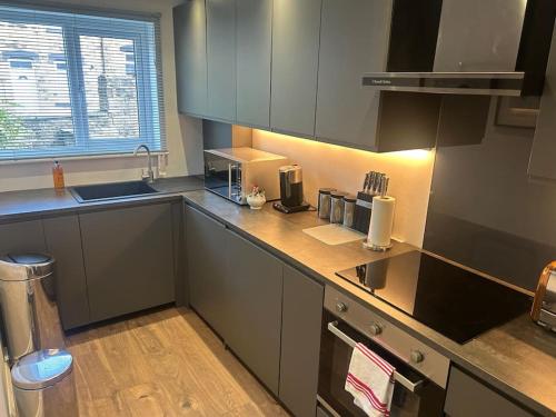 a kitchen with gray cabinets and a counter top at Best rated in Barnsley- apartment sleeps 4 & 5 minute walk to town centre in Barnsley