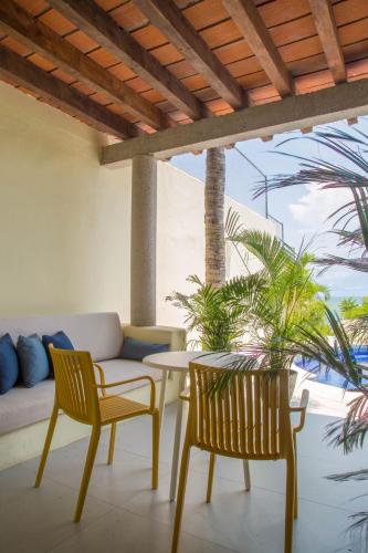 a patio with a couch and two chairs and a table at Hotel Ysuri Bucerias in Bucerías