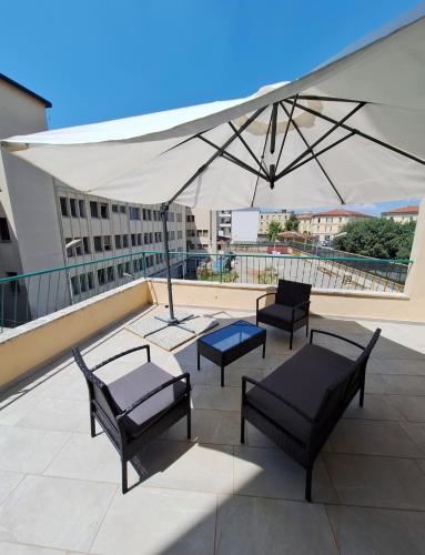 a patio with chairs and a white umbrella at Casa Vanessa in Arezzo