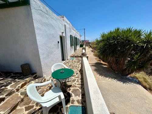 a table and two chairs sitting next to a building at Lukianos House in Tripití