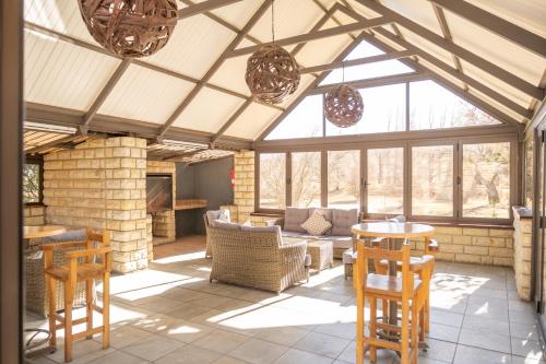 an open living room with a conservatory with windows at La La Nathi Country Guesthouse in Harrismith