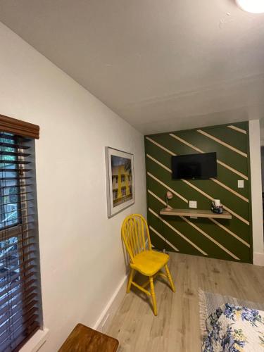 a yellow chair in a room with a wall at Cozy Room in the Heart of Little Havana in Miami