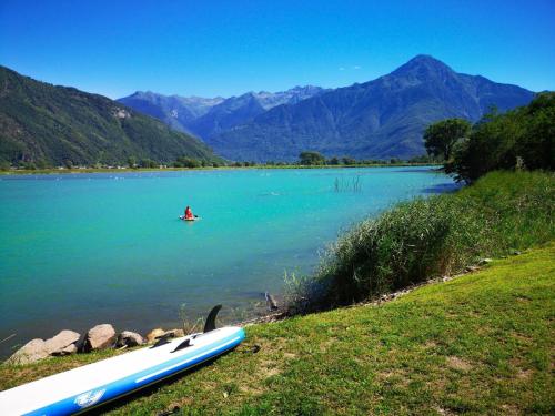 a person in a kayak in a body of water at Dascio Silence Ferienwohnung mit Panorama Balkon in Dascio