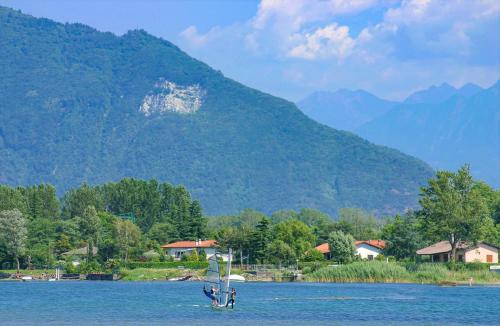 a boat in the water with mountains in the background at Dascio Silence Ferienwohnung mit Panorama Balkon in Dascio