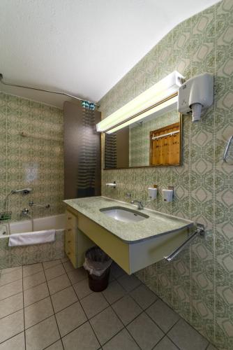a bathroom with a sink and a mirror at Chesa Silva - Silvaplana in Silvaplana