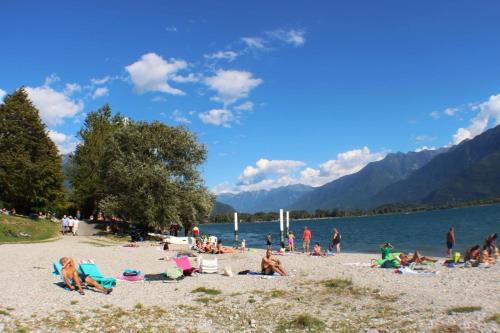 a group of people on a beach near a body of water at Dascio Paradise Ferienwohnung mit Dachterrasse am See in Dascio
