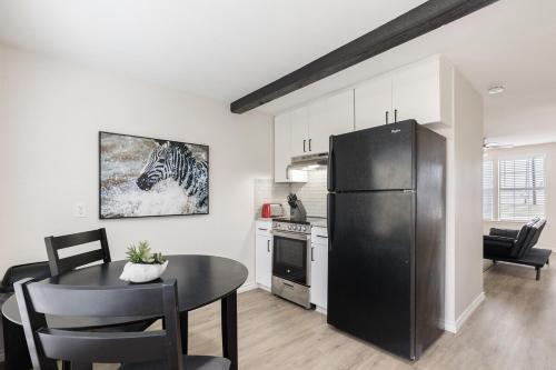 een keuken met een zwarte koelkast en een tafel bij Calmont Guest House in Fort Worth