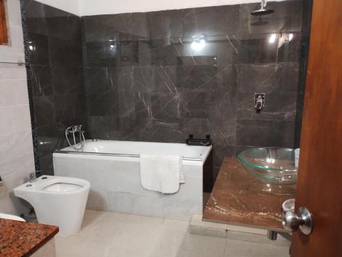 a bathroom with a tub and a toilet and a sink at Casa Solis in Balneario Solís