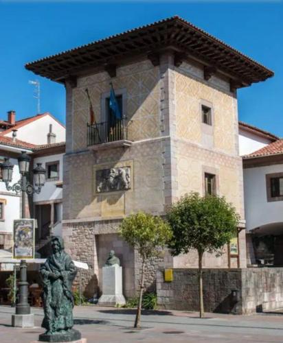 a building with a statue in front of it at Hotel Ciudad Cangas de Onis in Cangas de Onís