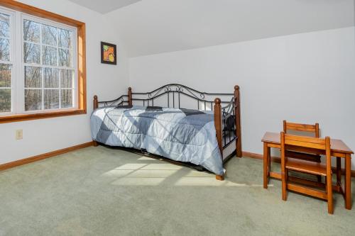 a bedroom with a bed and a table and a window at Serenity Chalet in Oakland