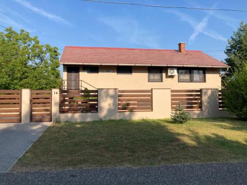 a house with a wooden fence in front of it at Avar Apartman in Nyíregyháza