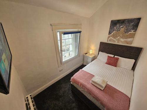 a small bedroom with a bed and a window at Shop Street Apartment in Galway