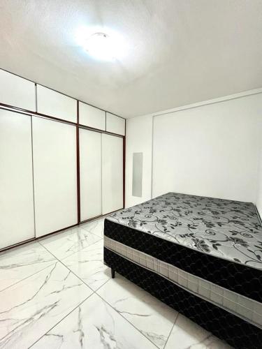 a bedroom with a bed in a room with marble floors at Flat Atlântico 405 in Fortaleza