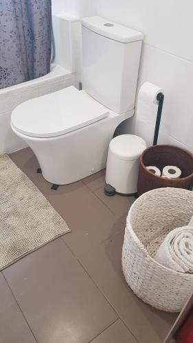 a white bathroom with a toilet and a rug at LITTLE PEACEFUL RETREAT Room with bath, Heating, Terrace, Free Wifi Fridge Easy parking in Nueva Andalucia